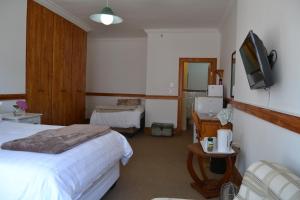 a hotel room with a bed and a television at Lekkerrus guesthouse in Krugersdorp