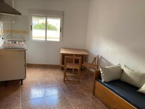 cocina con sofá, mesa y ventana en La casa de Paco el Ventero El Secadero, en Almócita