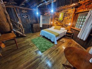 1 dormitorio con 1 cama en una cabaña de madera en Hosteria Flor de Canela, en Puyo