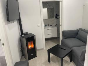 a living room with a couch and a wood burning stove at Casa Triacastela in Treacastela