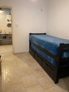 een slaapkamer met een bed met een blauwe deken erop bij Departamento Hospital Privado Quality maternidad Con cochera in Cordoba