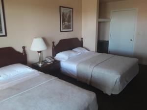 um quarto de hotel com duas camas e um candeeiro em Italy Inn em Italy