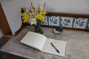 un bolígrafo y papel sobre una mesa con un jarrón de flores en The Loft at Strathardle - Lochside Apartment, Isle of Skye, en Dunvegan