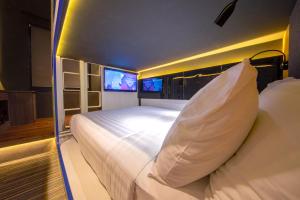 Un dormitorio con dos camas y dos televisores. en CUBE Family Boutique Capsule Hotel at Chinatown, en Singapur