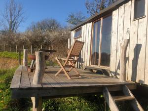 una terraza de madera con una silla y una mesa en Tiny Home, en Letterston