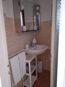 La salle de bains est pourvue d'un lavabo et d'un miroir. dans l'établissement Il Rifugio, nel cuore della Maremma Toscana, zona Saturnia, à Murci