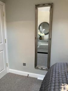 een slaapkamer met een spiegel aan de muur bij Rooftops - bijou sister apartment to Assembly View in Ludlow