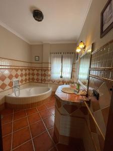 a large bathroom with a tub and a sink at Casa Charo in Valle de Abdalagís