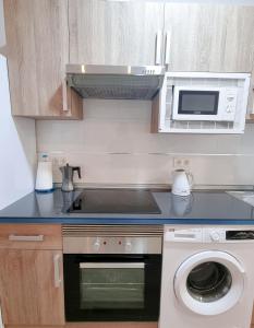 cocina con lavadora y microondas en Metropolitan apartments, en Madrid