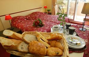 ein Korb mit Brot und Brotstangen auf dem Tisch in der Unterkunft Hôtel Maya in Cavalaire-sur-Mer