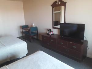 a bedroom with a television and a dresser with a mirror at Italy Inn in Italy +12 photos