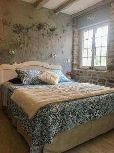 1 dormitorio con 1 cama grande con almohadas azules en "La chambre des TISSERANDS" en Ménil-Hubert-sur-Orne