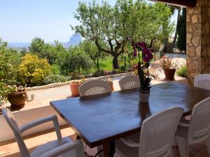 a wooden table and chairs on a patio at Chalet Cucarres in Calpe