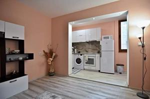 a kitchen with a white refrigerator and a dishwasher at Апартамент Фреш in Velingrad