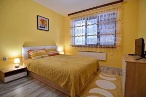 a bedroom with a large bed and a window at Апартамент Фреш in Velingrad