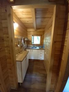 a kitchen in a log cabin with a sink at Veiga Mariña in A Xesteira
