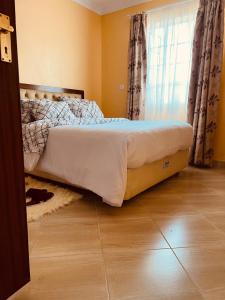 łóżko w sypialni z oknem w obiekcie Dala Luxury Home- Bondo w mieście Bondo