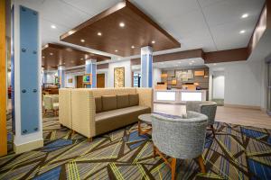 vestíbulo con sofá, mesas y sillas en Holiday Inn Express & Suites Sanford - Lake Mary, an IHG Hotel en Sanford