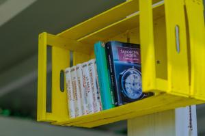 a row of books on a yellow shelf at B&B Tor Di Lupo in Mattinata
