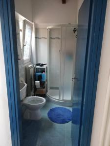 y baño con ducha, aseo y alfombra azul. en Casa Helios, en Albenga