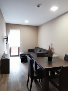 Kopaonik Lux Apartman في كوباونيك: غرفة معيشة مع طاولة وأريكة