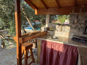 a kitchen with a sink and a counter with a window at Vacation house Milka in Milna