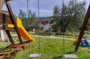 a playground with swings in a yard at B&B Tor Di Lupo in Mattinata
