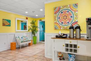 une cuisine avec des murs jaunes et une tapisserie colorée. dans l'établissement Cayman Suites Hotel, à Ocean City