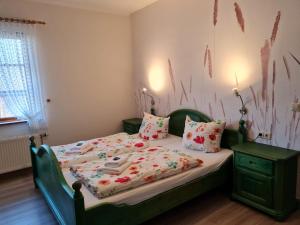 sypialnia z łóżkiem z zielonym zagłówkiem i poduszkami w obiekcie Reethäuser auf Rügen w mieście Middelhagen