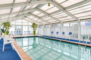 una piscina con sedie blu e soffitto di Cayman Suites Hotel a Ocean City