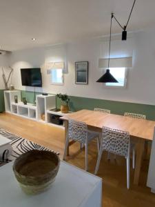 een woonkamer met een houten tafel en stoelen bij Bel appartement vue mer - 1er rang front de mer in Saint-Jean-de-Luz