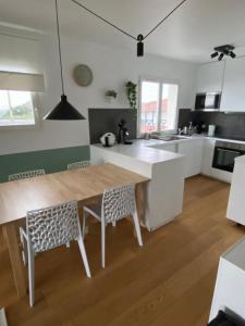 een keuken met een houten tafel en stoelen in een kamer bij Bel appartement vue mer - 1er rang front de mer in Saint-Jean-de-Luz