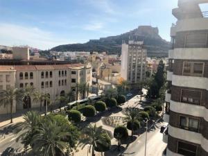 a city with buildings and palm trees and a mountain at Eternity Alicante in Alicante