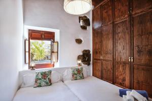 
a bedroom with a white bed and white walls at Hotelito Rural Flor de Timanfaya in Tinajo
