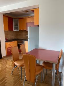 kuchnia ze stołem, krzesłami i lodówką w obiekcie Apartman Andjela w mieście Vrnjačka Banja