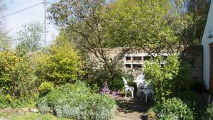 a garden with a table and chairs and trees at Hadrian's Barn in Heddon on the Wall