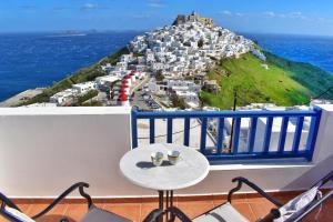 a table on a balcony with a view of a city at Castelli Studios in Astypalaia Town