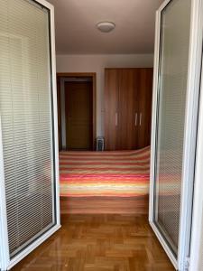 sypialnia z łóżkiem i przesuwnymi szklanymi drzwiami w obiekcie Apartman Andjela w mieście Vrnjačka Banja