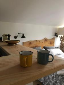 Zwei Kaffeetassen stehen auf einem Holztisch in der Unterkunft Baiolei in Azpeitia