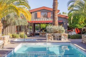 a house with a swimming pool and a palm tree at Sparrows Lodge in Palm Springs
