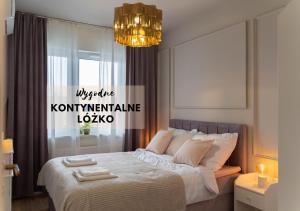 1 dormitorio con 1 cama con 2 toallas en Złote Krany Apartament Termalny, en Uniejów