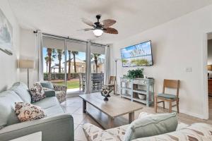 ein Wohnzimmer mit Sofa und Tisch in der Unterkunft Bristol 109 - Lovely Ground Floor Beachfront Unit in Gulf Shores