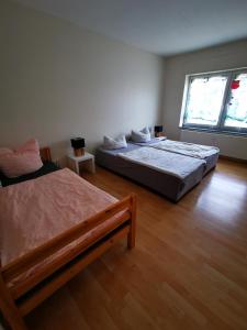 a bedroom with two beds and a large window at Pension No. 12 in Ketzin