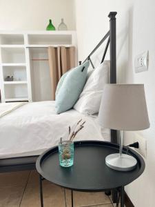 una mesa negra con una lámpara y una cama en Is Scabas Guestrooms, en Solarussa