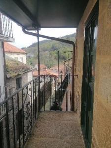 eine Gasse mit einem Balkon, auf dem eine Katze sitzt in der Unterkunft Casiña da Madalena in Ribadavia
