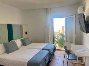 a hotel room with two beds and a balcony at HOTEL BOUTIQUE CABO SUR in Mojácar