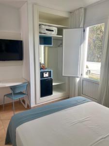 a bedroom with a bed and a desk and a window at HOTEL BOUTIQUE CABO SUR in Mojácar