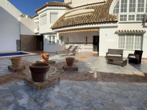 un patio con tavolo da biliardo e una casa di Villa Casa Vega Fuengirola a Fuengirola
