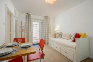 Apartments Zicara في دوبروفنيك: غرفة نوم بسرير وطاولة مع كراسي حمراء
