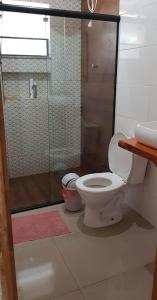 uma casa de banho com um WC e uma cabina de duche em vidro. em Chalé no campo à caminho de Monte Verde em Camanducaia